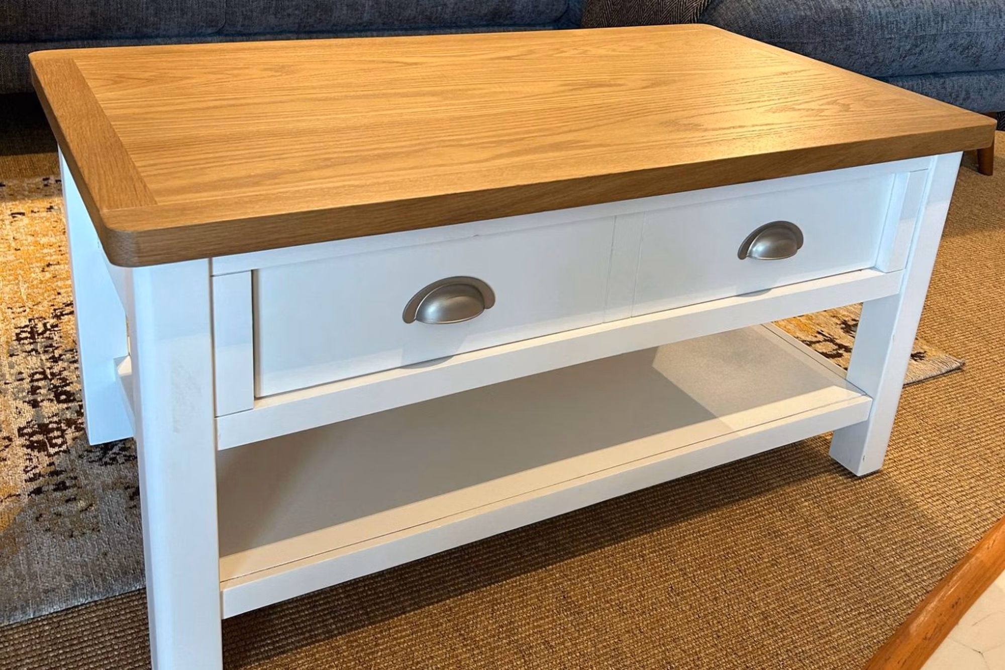 Angled view of the Gilroy Large Coffee Table with storage drawers and lower shelf.